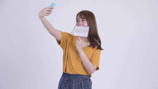 Jovem feliz bela mulher asiática tomando selfie com sinal de papel — Vídeo de Stock