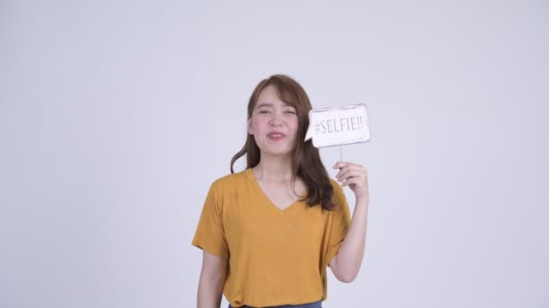 Feliz jovem bela mulher asiática com selfie sinal de papel — Vídeo de Stock