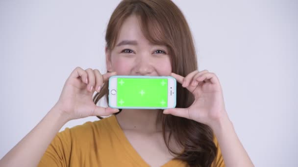 Visage de heureux jeune asiatique femme montrant téléphone — Video