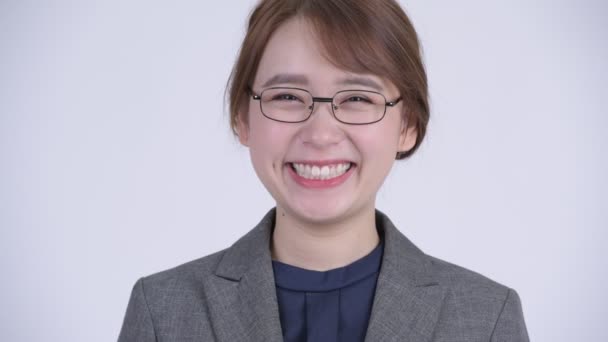 Лицо молодой счастливой азиатской бизнесвумен в очках улыбается — стоковое видео