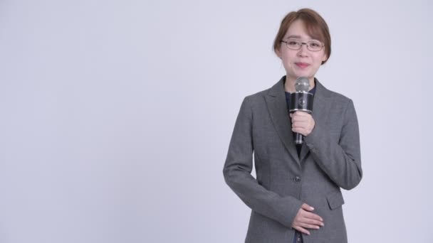 Unga asiatiska affärskvinna som nyhetsuppläsare visar något — Stockvideo