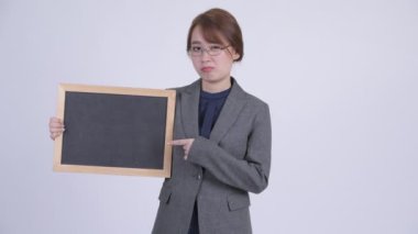 Blackboard tutarak ve aşağı Yaşasın vererek genç ciddi Asya işkadını
