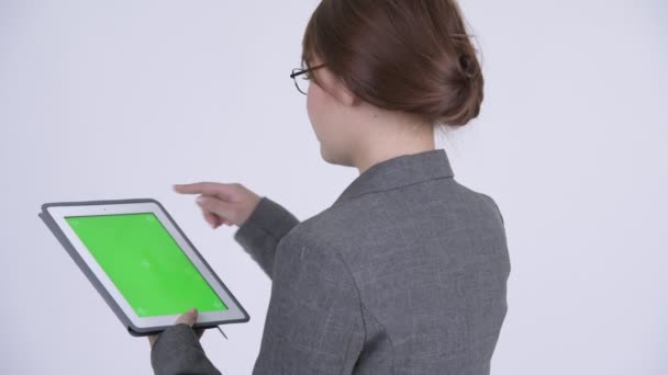 Vue arrière de jeune femme d'affaires asiatique heureuse utilisant une tablette numérique 