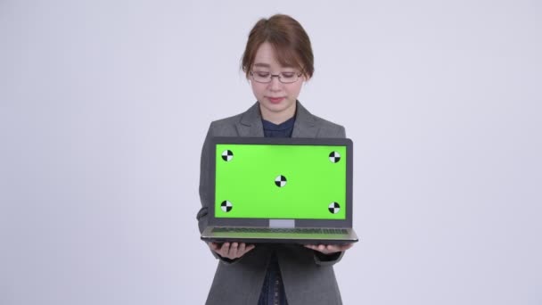 Dizüstü bilgisayarı gösteren ve sürpriz arıyor genç mutlu Asya işkadını — Stok video