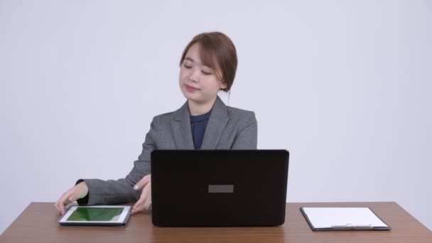 Junge glückliche asiatische Geschäftsfrau Multitasking bei der Arbeit — Stockvideo