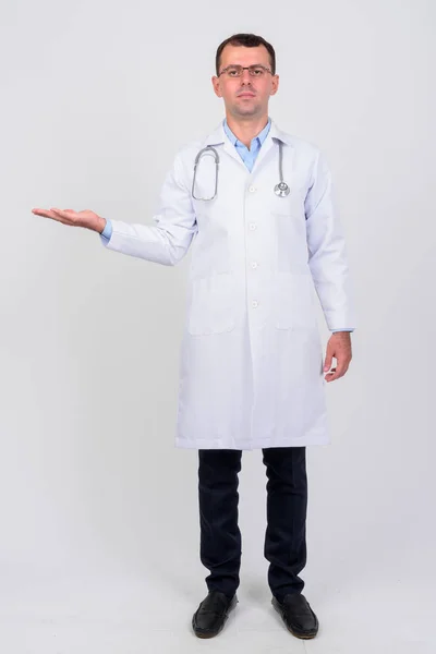 Full body shot of man doctor with eyeglasses showing something — Stock Photo, Image