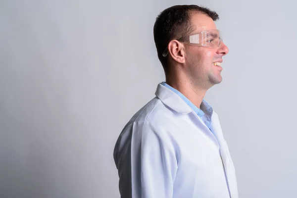 Visão de perfil de close-up de homem feliz médico com óculos de proteção sorrindo — Fotografia de Stock