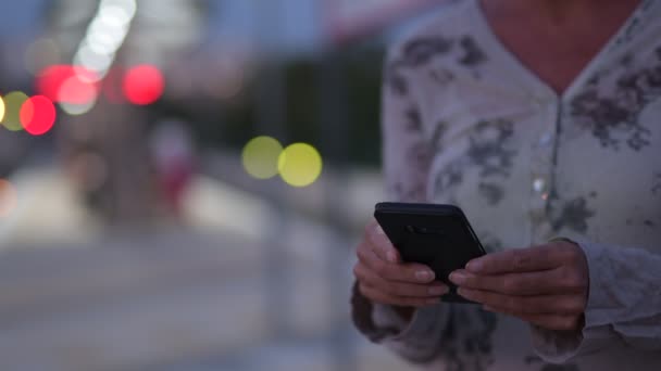 Mains de femme mûre utilisant le téléphone à la gare — Video