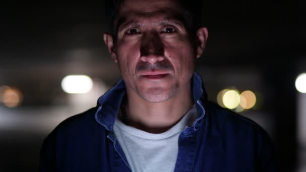 Hombre hispano de aspecto sospechoso pensando en estacionamiento oscuro — Vídeos de Stock