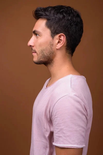 茶色の背景に対して若いハンサムなヒスパニック系男性 — ストック写真