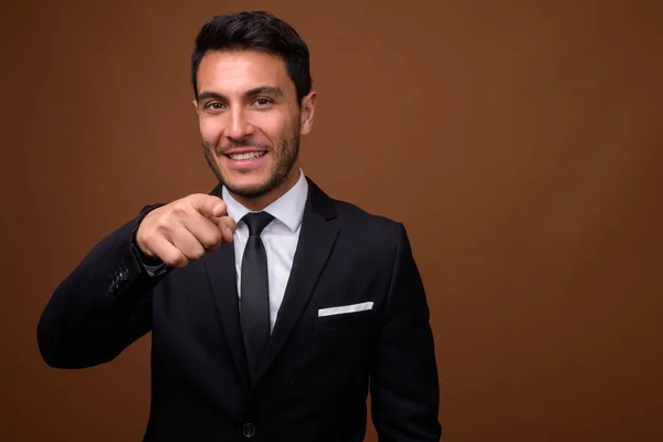 Junger gutaussehender hispanischer Geschäftsmann mit braunem Hintergrund — Stockfoto