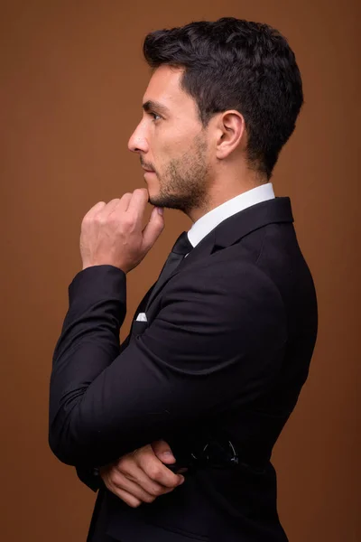Fiatal jóképű spanyol üzletember barna háttér — Stock Fotó
