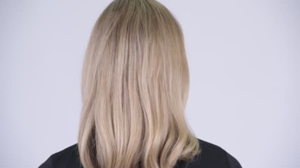 Vue arrière rapprochée de jeune femme blonde heureuse souriante et regardant en arrière — Video