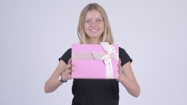 Young happy blonde woman giving gift box — Stock Video