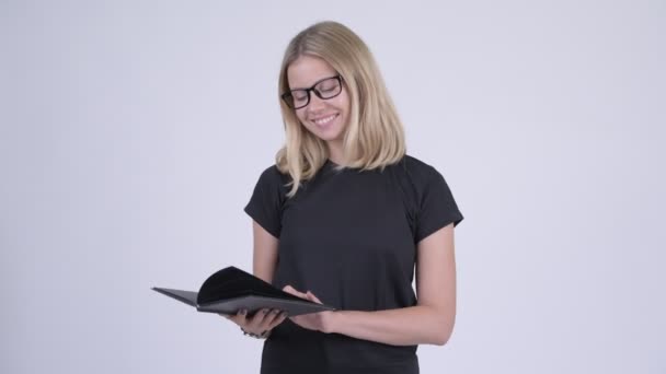 Giovane donna nerd bionda felice pensando durante la lettura del libro — Video Stock
