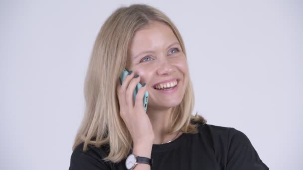 Gesicht einer jungen glücklichen blonden Frau, die am Telefon spricht — Stockvideo