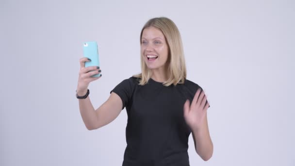 Jovem mulher loira feliz vídeo chamando com telefone — Vídeo de Stock