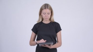 Dijital tablet kullanırken düşünerek mutlu sarışın genç kadın