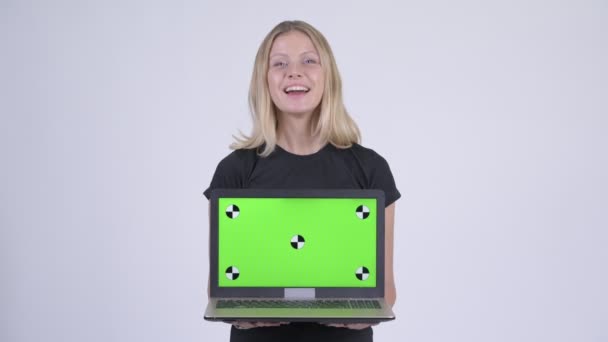 年轻快乐的金发碧眼的女人一边说话, 一边展示笔记本电脑 — 图库视频影像