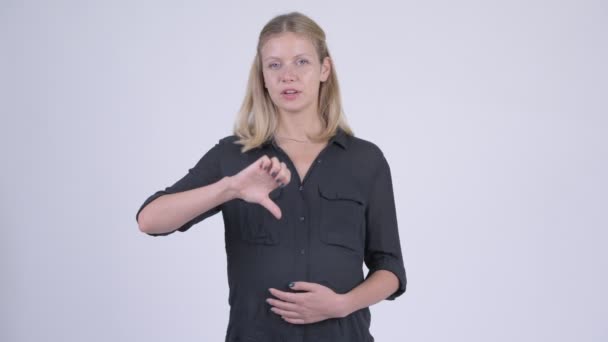 Young serious pregnant businesswoman giving thumbs down — Stock Video