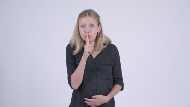 Fiatal szép terhes üzletasszony ujjal ajkán — Stock videók