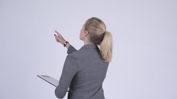 Задний вид молодой блондинки-предпринимательницы, направляющей и указывающей пальцем — стоковое видео