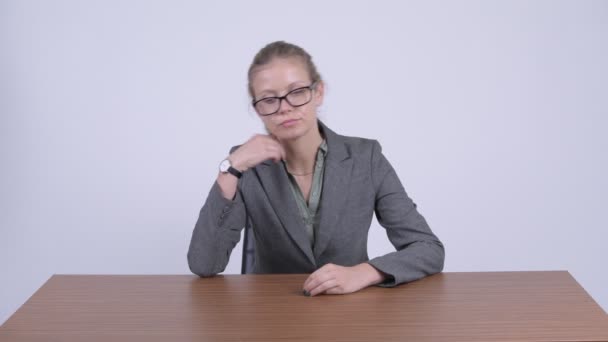 Junge gestresste blonde Geschäftsfrau sieht gelangweilt und müde am Schreibtisch aus — Stockvideo