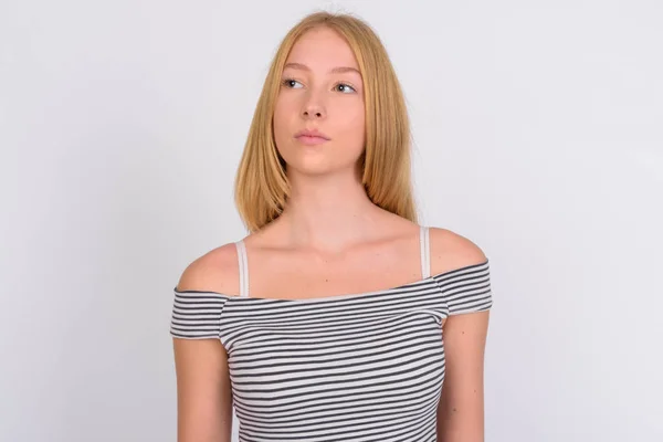 Gesicht der jungen schönen blonden Teenagerin, die nachdenkt und nach oben schaut — Stockfoto