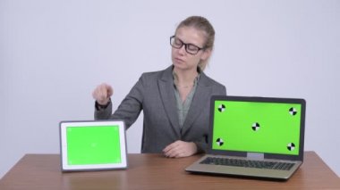 Genç güzel sarışın işkadını dizüstü bilgisayar ve dijital tablet gösterilen süre konuşmak