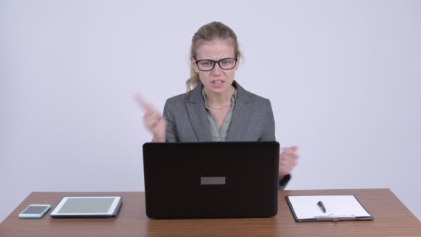 Jonge boos blonde zakenvrouw videobellen met laptop op het werk — Stockvideo