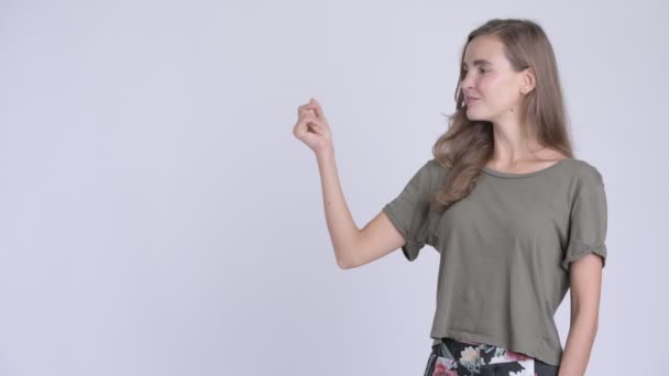 Счастливая молодая красивая женщина щелкает пальцами и показывает что-то — стоковое видео