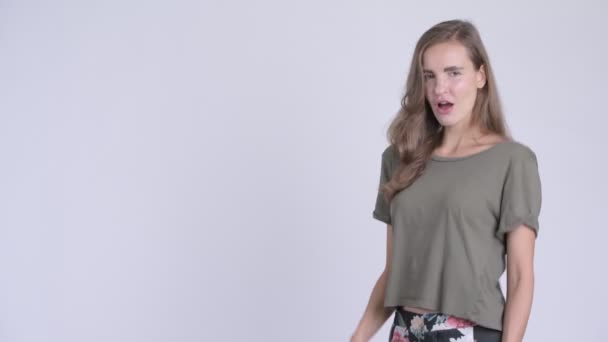 Lykkelig ung smuk kvinde peger fingre og viser noget – Stock-video