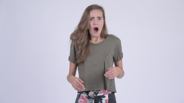 Молода стресова жінка, яка виглядає засмученою, отримуючи погані новини — стокове відео