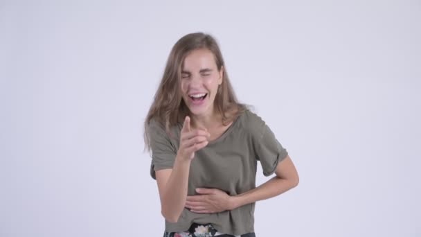 Glückliche junge schöne Frau lacht und zeigt in die Kamera — Stockvideo