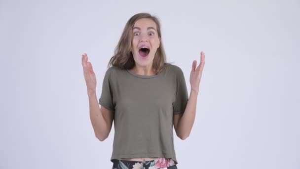 Glückliche junge schöne Frau sieht überrascht aus — Stockvideo