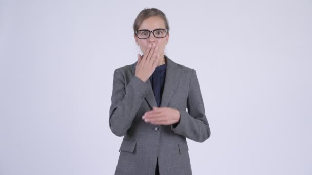Молода шокована бізнес-леді прикриває рот і виглядає винною — стокове відео