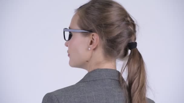 Vista trasera de cerca de la joven mujer de negocios hermosa mirando hacia atrás y quitándose las gafas — Vídeos de Stock