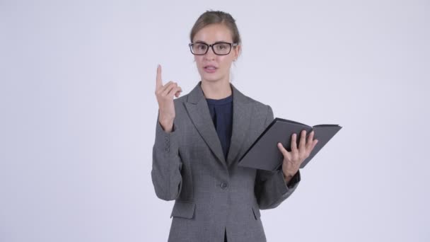 Jonge mooie zakenvrouw praten tijdens het lezen van boek — Stockvideo