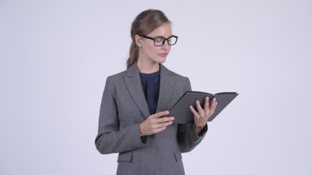 Young shy businesswoman covering face with book — Stock Video