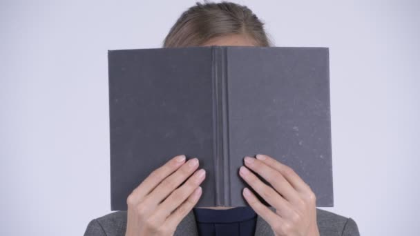 Volto di giovane imprenditrice che pensa mentre copre il viso con il libro — Video Stock