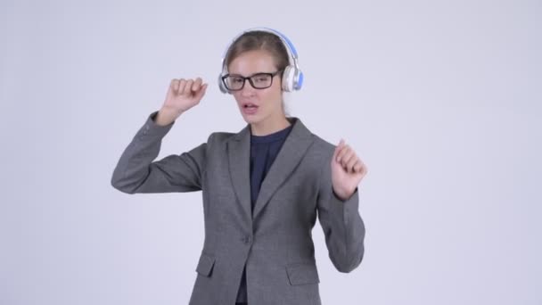 Joven mujer de negocios feliz escuchando música y bailando — Vídeos de Stock