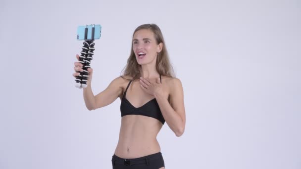 Glückliche junge schöne Frau im Bikini vlogging und zeigt Telefon — Stockvideo