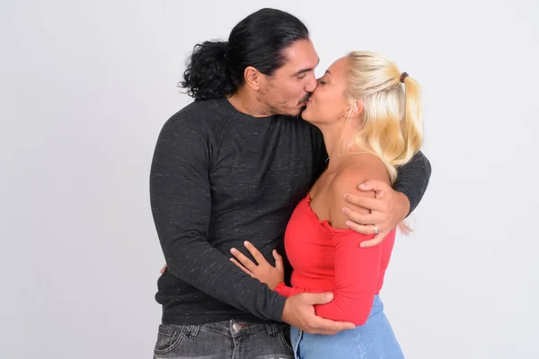 Estúdio tiro de jovem casal beijando juntos — Fotografia de Stock