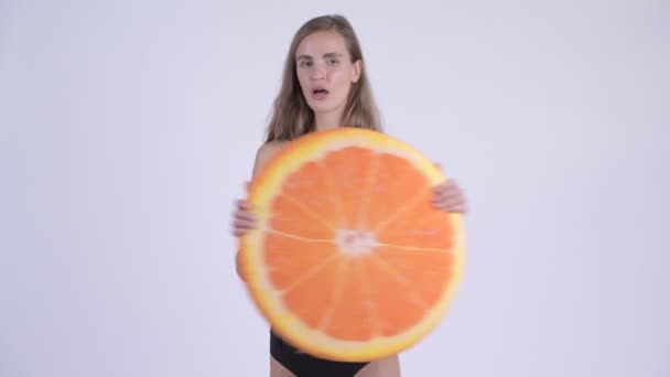 Glad ung vacker kvinna i bikini hålla orange kudde som friska begrepp — Stockvideo