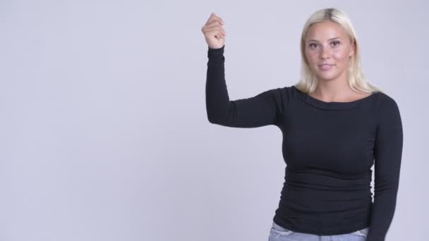 Parmak yapışmayı hem de bir şeyler gösteriyor mutlu sarışın genç kadın — Stok video
