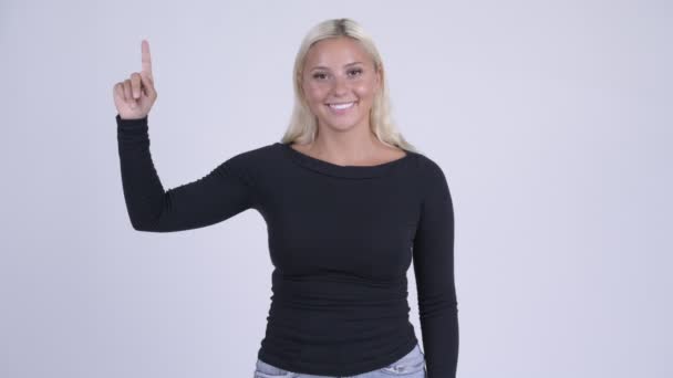 Junge glückliche blonde Frau zeigt nach oben — Stockvideo