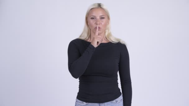 Ung vacker blond kvinna med finger på läppar — Stockvideo