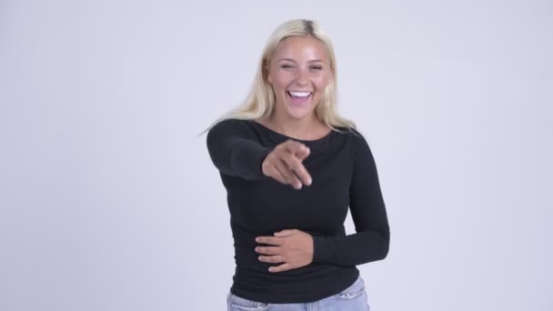 Jovem mulher loira feliz rindo e apontando para a câmera — Vídeo de Stock