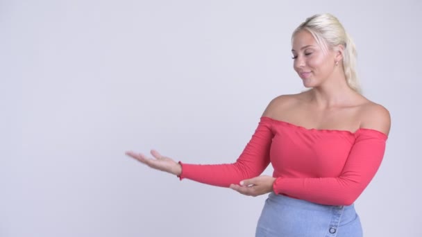 Happy young beautiful blonde woman showing something — Stock Video