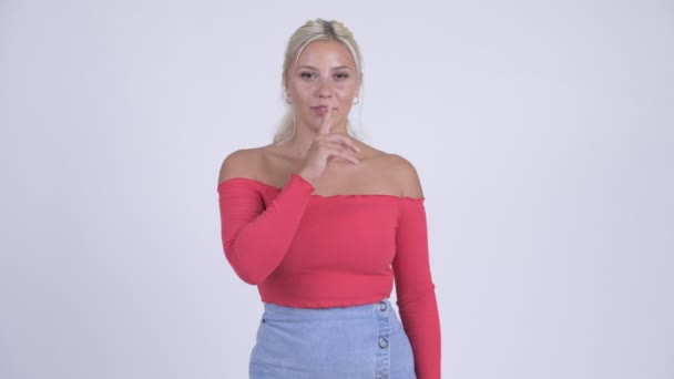 Glad ung vacker blond kvinna med finger på läppar — Stockvideo